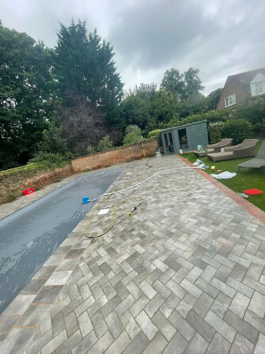 A block paving path running along a garden